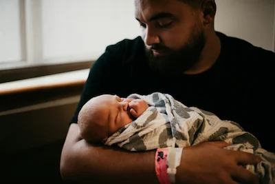 Father holding newborn baby.